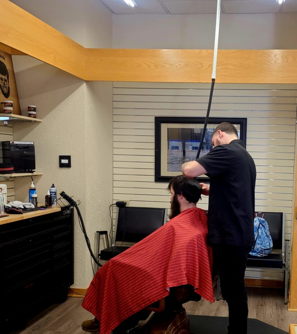 A man is getting his hair cut by another person.