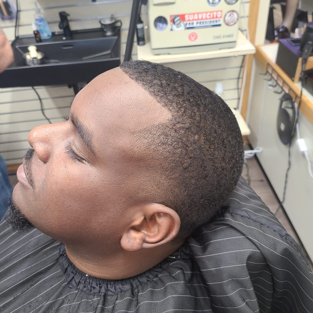 A man getting his hair cut at the barber shop